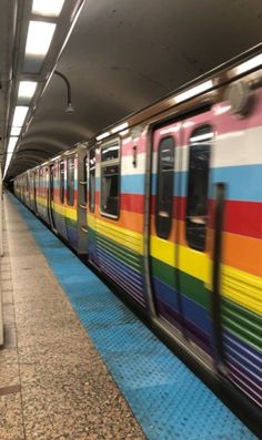 a rainbow colored train pulling into the station