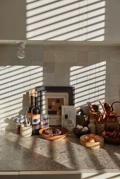 the kitchen counter is covered with food and wine