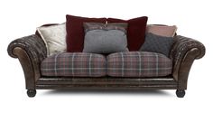 a brown leather couch with many pillows on it's back and arms, sitting in front of a white background