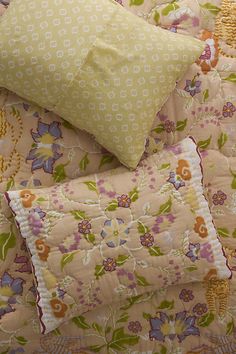 the comforter is made up with many different patterns and colors, including flowers on it