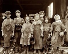 a group of children standing next to each other holding buckets