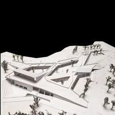 an architectural model of a building on top of snow covered ground with trees in the foreground