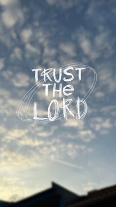 the words trust the lord are drawn in front of a cloudy sky