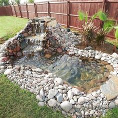 a small pond with rocks and water flowing from it