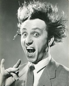 an old black and white photo of a man with his hair blowing in the wind