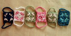 four crocheted purses lined up on a table