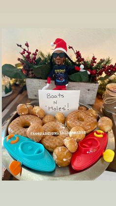 a tray filled with donuts sitting on top of a table next to a sign