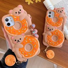 two phone cases with donuts and bears on them, one is holding an iphone