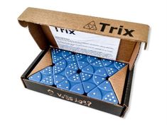 a box filled with blue dices on top of a white surface