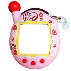 a pink and yellow toy frame with a red ball on it's end, sitting next to a pair of scissors