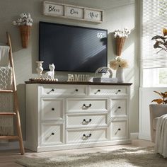 a white dresser sitting in a bedroom next to a window with flowers on top of it