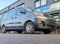 a grey van parked in front of a building