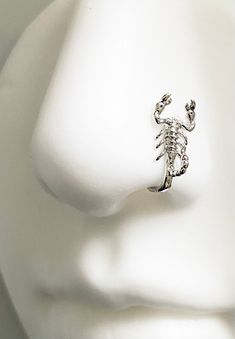 a white mannequin head with a scorpion ring on it