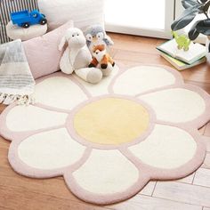 a child's room with toys on the floor and a rug in the shape of a flower