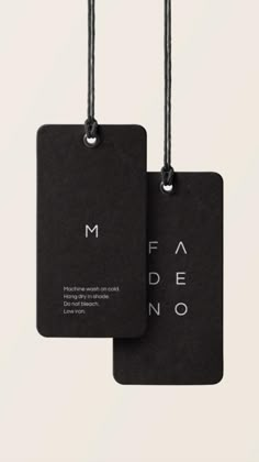 two black tags hanging from strings with the word fadno written in white on them