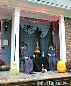 two people dressed up as witches sitting on the porch with pumpkins in front of them