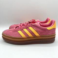 Elevate your sneaker game with these bold and colorful Adidas Women's Gazelle sneakers. With a pink and orange colorway, these shoes are sure to make a statement wherever you go. The suede upper material is both stylish and durable, making these shoes perfect for everyday wear. Featuring the iconic Adidas three stripes and a comfortable athletic design, these sneakers are both fashionable and functional. The size 11 shoes are made for women and are part of the Adidas Gazelle product line. Don't miss your chance to add these stylish sneakers to your collection. Colorful Adidas, Gazelle Bold, Adidas Three Stripes, Girls Stuff, Money Talks, Sneaker Games, Adidas Gazelle, Stylish Sneakers, Christmas Wishlist