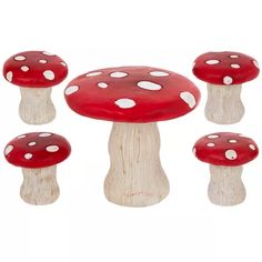 four red mushrooms with white dots on them are sitting in the middle of a row