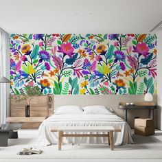 a bedroom decorated with colorful flowers and plants on the wall, along with a bed