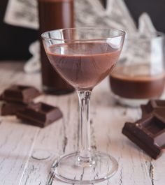 a glass filled with liquid next to some chocolate