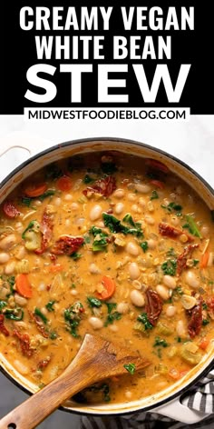 creamy vegan white bean stew in a pot with a wooden spoon