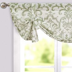 a window with a curtain and valance on it's side, in front of a white wall