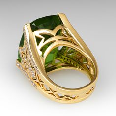 This magnificent cocktail ring is centered with one (1) cushion mixed cut natural peridot set into a four-prong setting. The ring features a pierced design and is accented with fifty-four (54) bead set, round brilliant cut diamonds. The diamonds are bordered with milgrain edging. The ring measures 21.6mm at the top, rises 13.9mm above the finger, tapering to 6.8mm wide and 1.0mm thick at the base of the shank. The ring size 7 and only very limited resizing is available. Diamond Cocktail Ring, Diamond Cocktail Rings, Bead Set, One 1, Round Brilliant Cut Diamond, Cocktail Ring, Brilliant Cut Diamond, Cocktail Rings, Round Brilliant