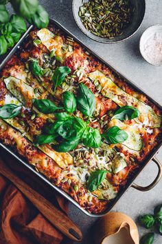 a casserole dish with spinach, cheese and other ingredients on the side