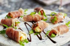 small appetizers are arranged on a marble platter