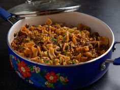 a blue pot filled with pasta and meat