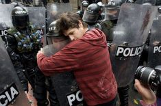 a man is hugging his face in front of police officers with text that reads, f k the police gently