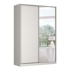 a white cabinet with mirrored doors and a lamp on the table in front of it