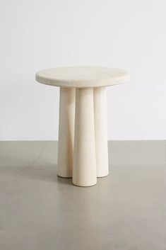 a white table sitting on top of a cement floor