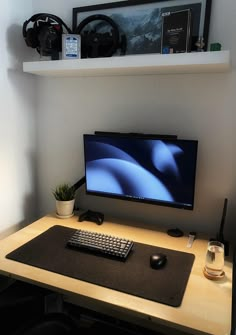 a computer monitor sitting on top of a wooden desk next to a keyboard and mouse