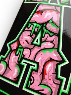 a skateboard with pink and green graffiti on it