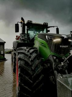 a tractor parked in front of a house on a rainy day with dark clouds overhead