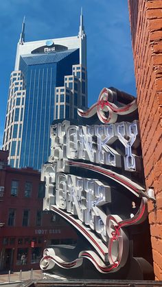 a large sign on the side of a building in front of tall buildings and skyscrapers