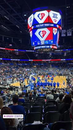 a basketball game is being played in an arena with people sitting on the sidelines