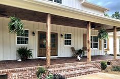 the front porch is covered with plants and potted plants