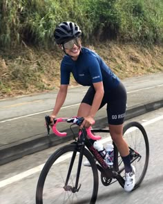 a woman riding a bike down the road