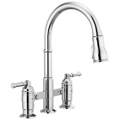 a kitchen faucet with two handles and nozzles