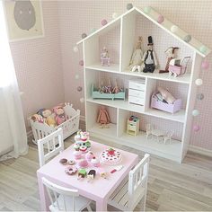 a doll house with pink walls and white furniture