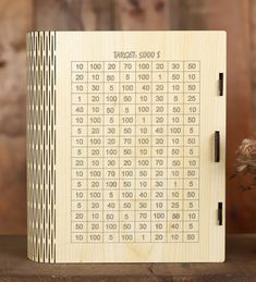 a wooden game board with numbers and times on the front, sitting on a table