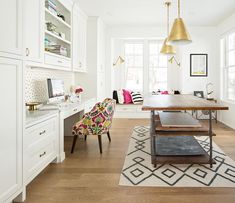 a room with white walls, wooden floors and lots of furniture in the center area