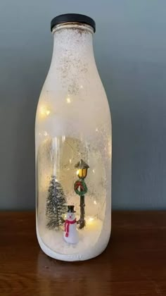 a glass jar with a snowman inside on a table