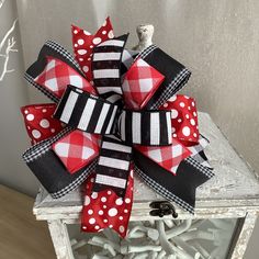 a red and black bow with white polka dots on the top is sitting on a table