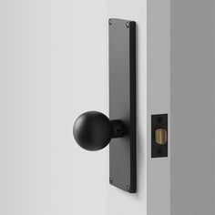 a black door handle on a white wall