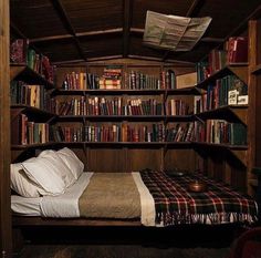 a bed in a room with lots of books on the shelves