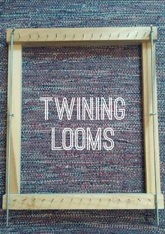 the words twining looms written in white on a wooden frame