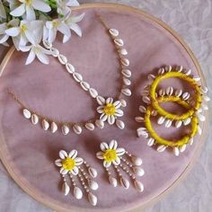 a close up of a piece of jewelry on a table with flowers in the background